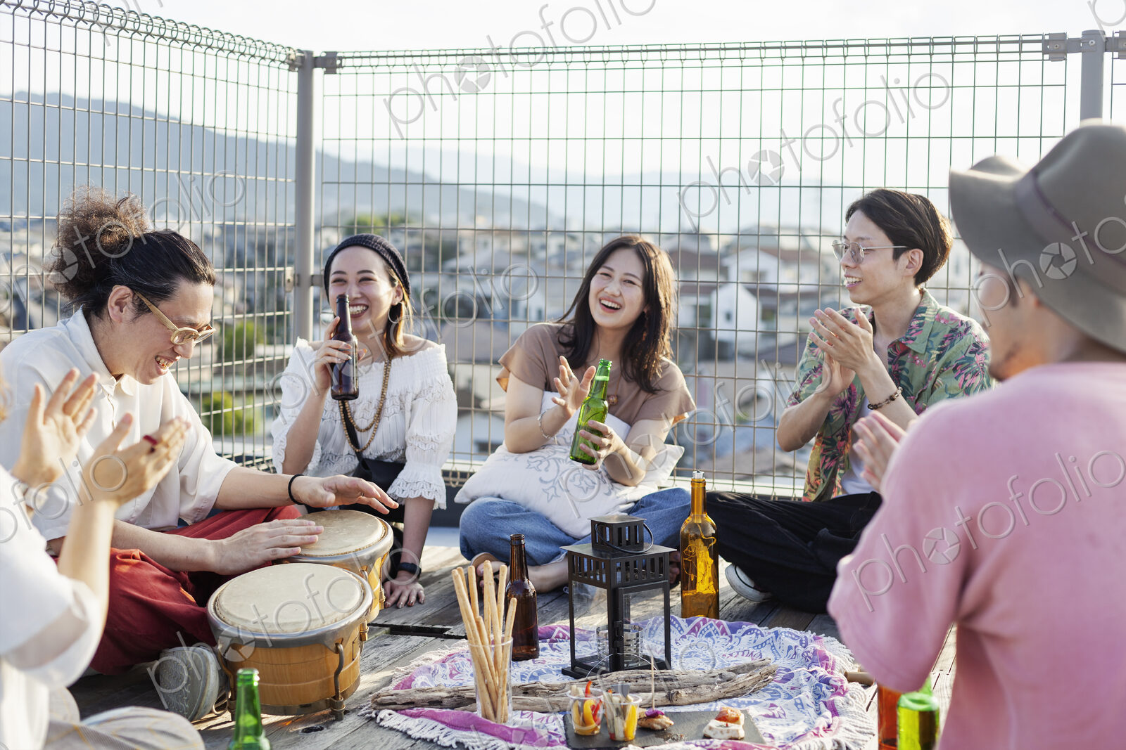 Group of young Japanese men and women standing on a rooftop in an urban setting.