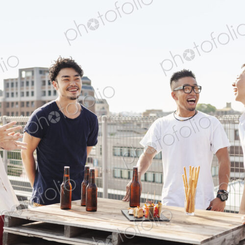 Group of young Japanese men and women standing on a rooftop in an urban setting,… Group of young Japanese men and women standing on a rooftop in an urban setting,…