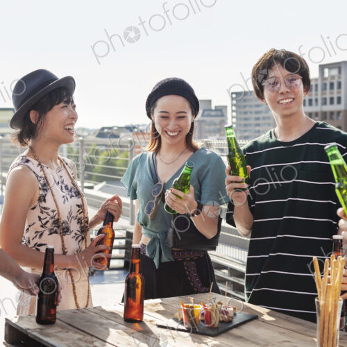 Group of young Japanese men and women standing on a rooftop in an urban setting,… Group of young Japanese men and women standing on a rooftop in an urban setting,…