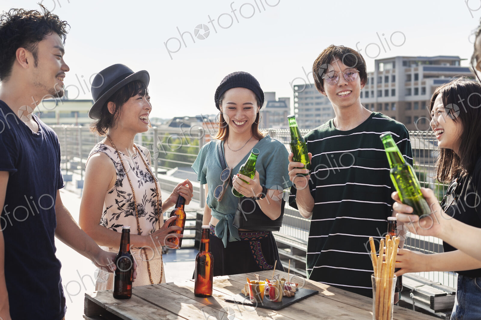 Group of young Japanese men and women standing on a rooftop in an urban setting,…