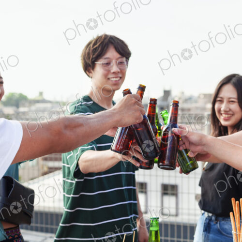 Group of young Japanese men and women standing on a rooftop in an urban setting,… Group of young Japanese men and women standing on a rooftop in an urban setting,…