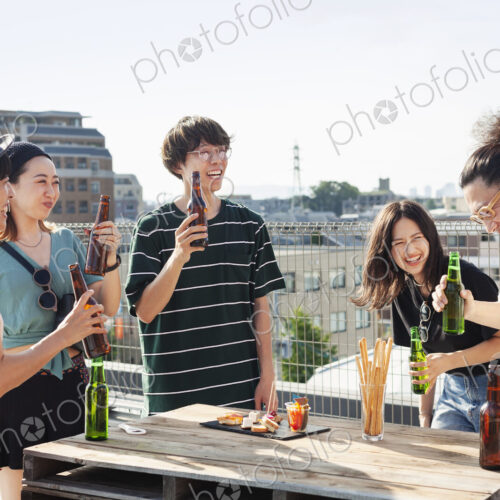 Group of young Japanese men and women standing on a rooftop in an urban setting,… Group of young Japanese men and women standing on a rooftop in an urban setting,…