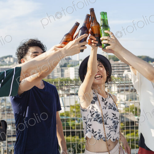 Group of young Japanese men and women standing on a rooftop in an urban setting,… Group of young Japanese men and women standing on a rooftop in an urban setting,…