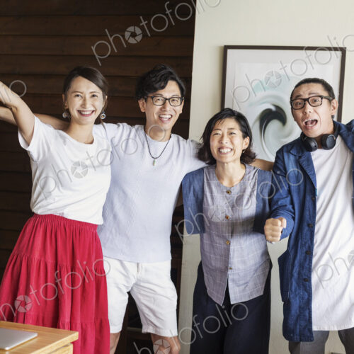 Group of young Japanese professionals in a co-working space, smiling and cheering at… Group of young Japanese professionals in a co-working space, smiling and cheering at…