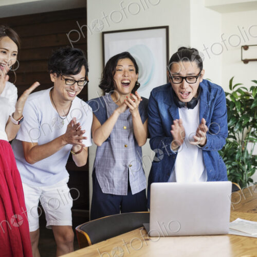 Group of young Japanese professionals looking at laptop computer in a co-working… Group of young Japanese professionals looking at laptop computer in a co-working…