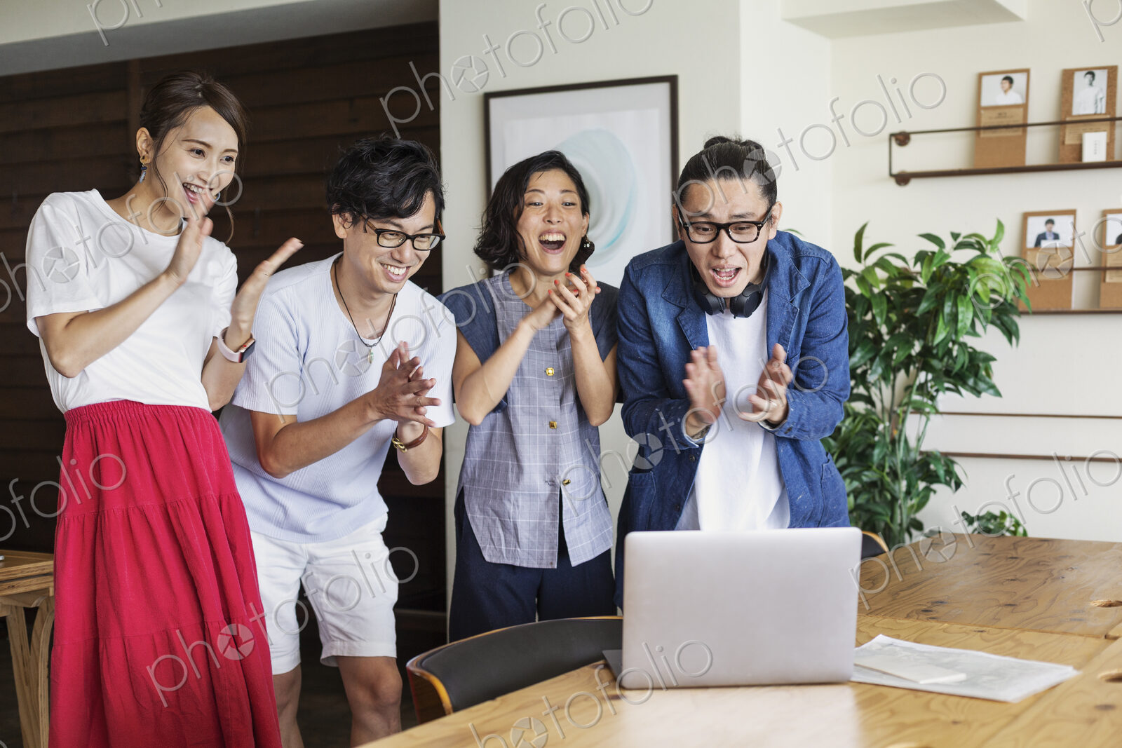 Group of young Japanese professionals looking at laptop computer in a co-working…