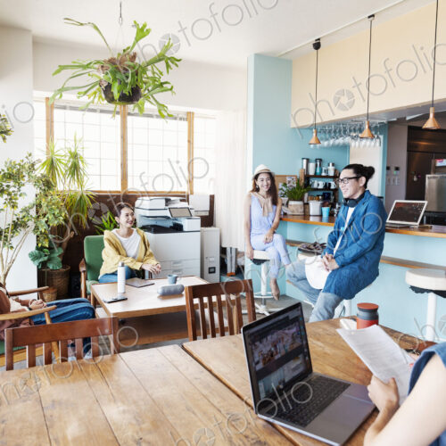 Group of young Japanese professionals working on laptop computers in a co-working space. Group of young Japanese professionals working on laptop computers in a co-working space.