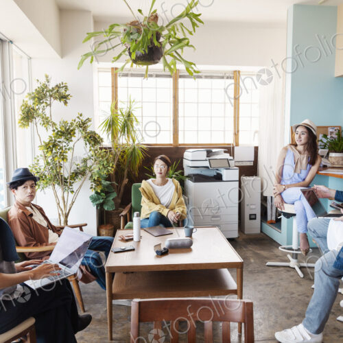 Group of young Japanese professionals working on laptop computers in a co-working space. Group of young Japanese professionals working on laptop computers in a co-working space.