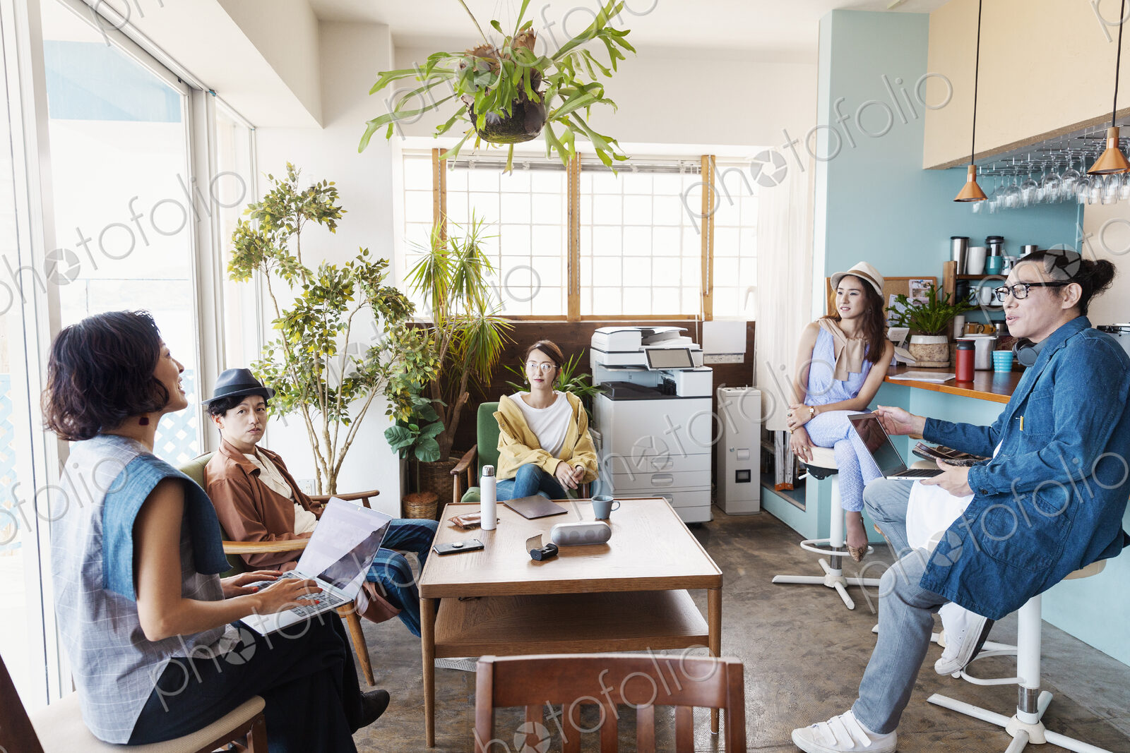 Group of young Japanese professionals working on laptop computers in a co-working space.