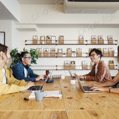 Group of young Japanese professionals working on laptop computers in a co-working space. Group of young Japanese professionals working on laptop computers in a co-working space.
