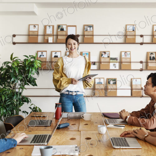Group of young Japanese professionals working on laptop computers in a co-working space. Group of young Japanese professionals working on laptop computers in a co-working space.