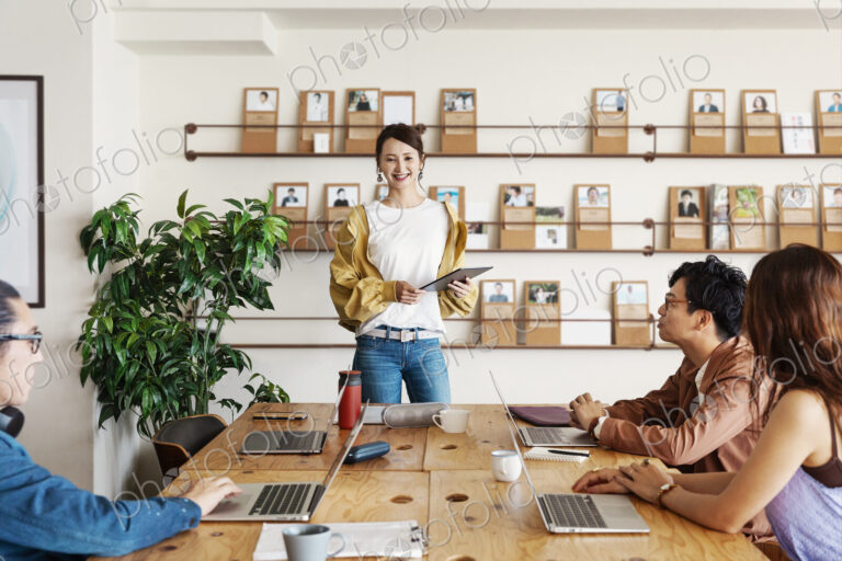 Group of young Japanese professionals working on laptop computers in a co-working space.