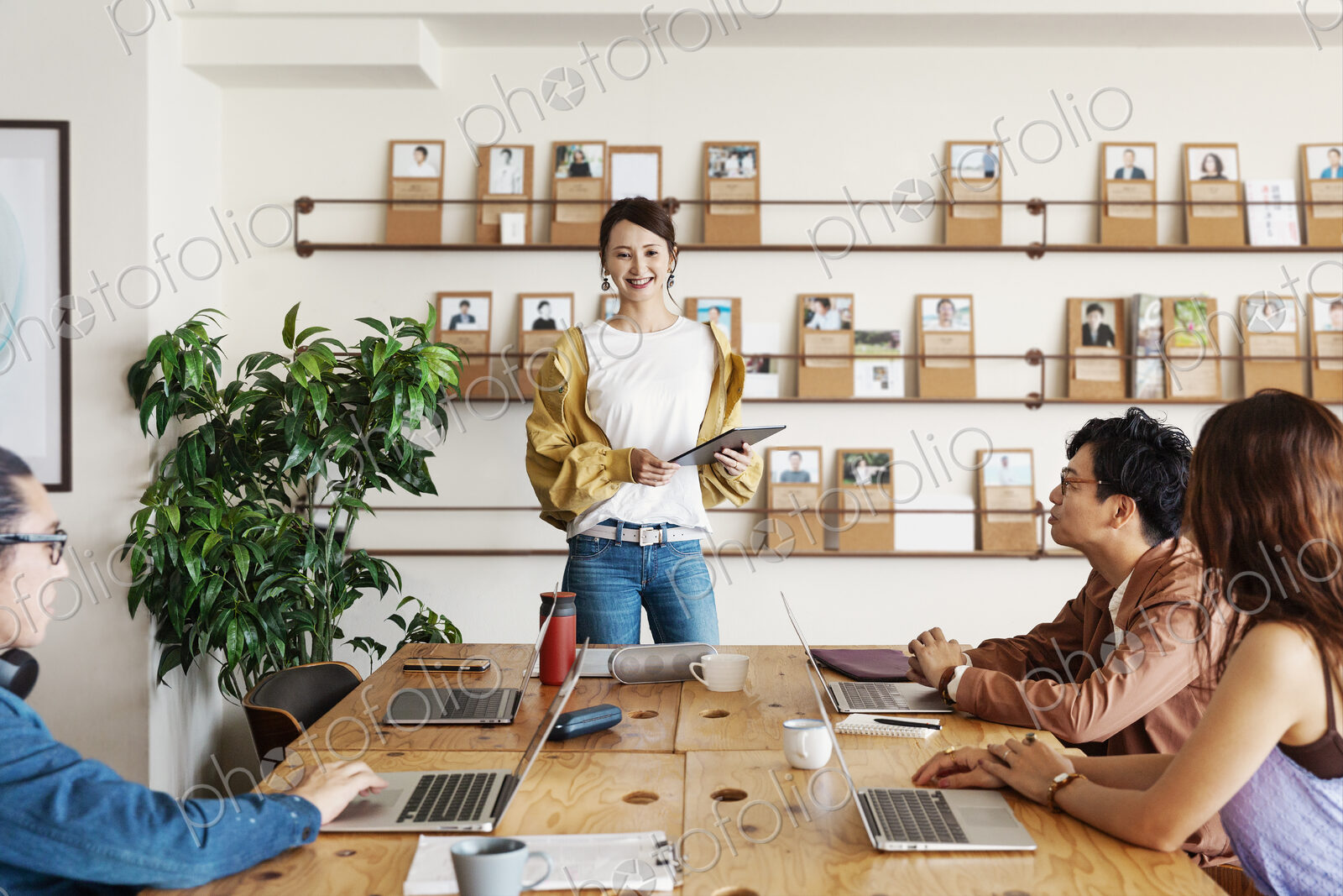 Group of young Japanese professionals working on laptop computers in a co-working space.