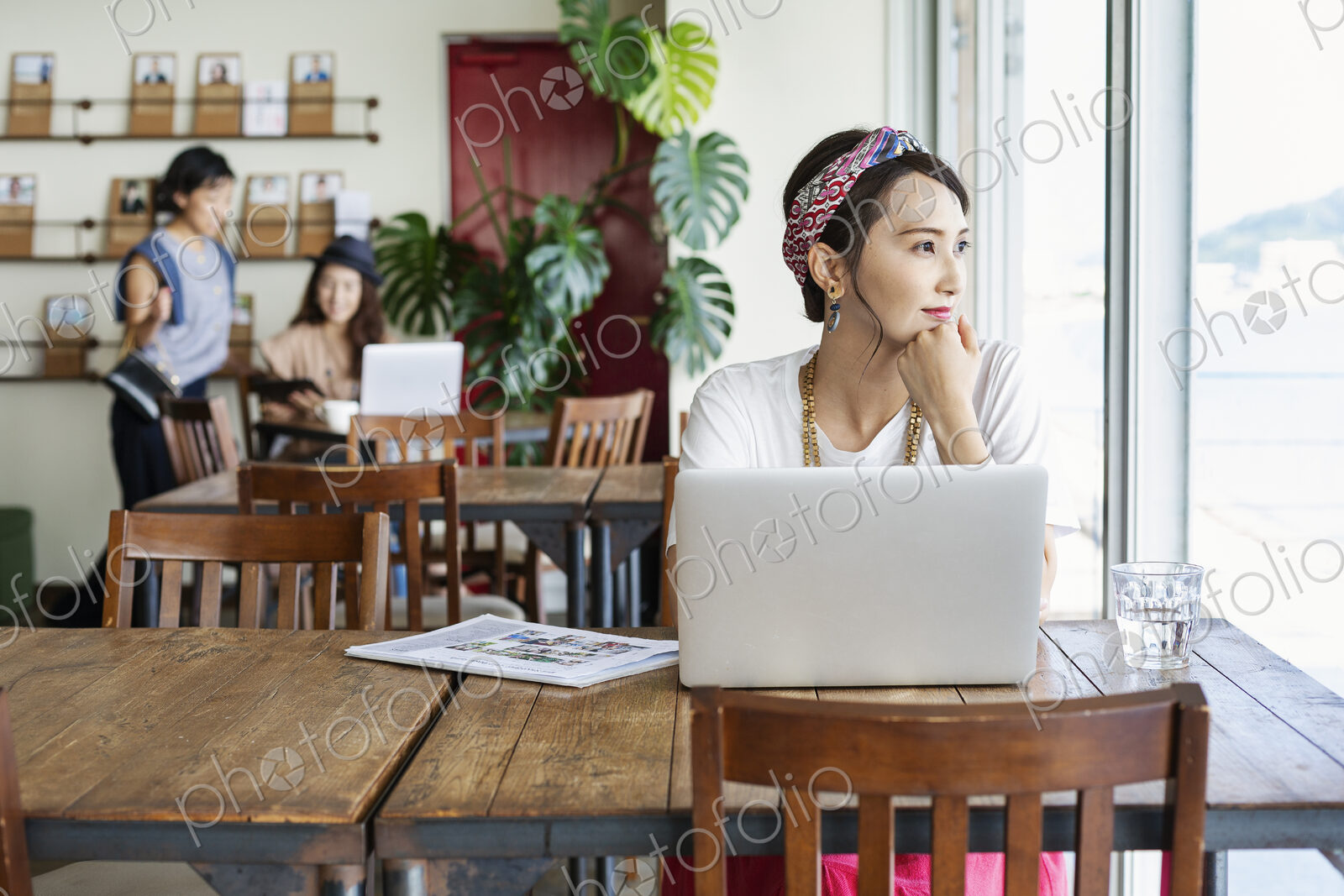 Group of young Japanese professionals working on laptop computers in a co-working space.
