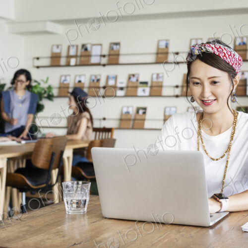 Group of young Japanese professionals working on laptop computers in a co-working space. Group of young Japanese professionals working on laptop computers in a co-working space.