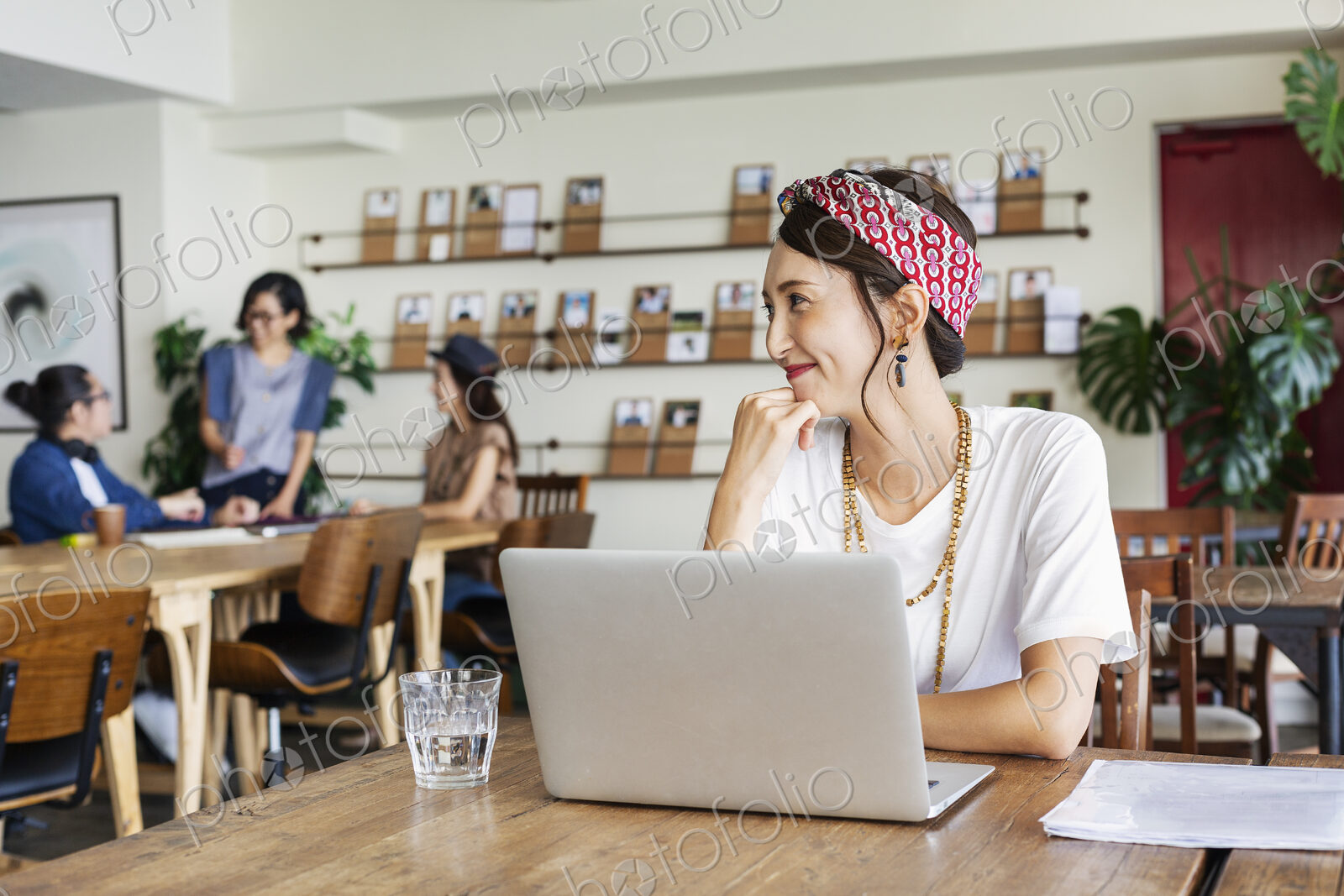 Group of young Japanese professionals working on laptop computers in a co-working space.