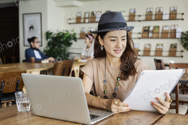 Group of young Japanese professionals working on laptop computers in a co-working space.