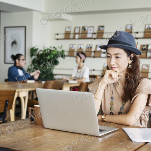 Group of young Japanese professionals working on laptop computers in a co-working space. Group of young Japanese professionals working on laptop computers in a co-working space.