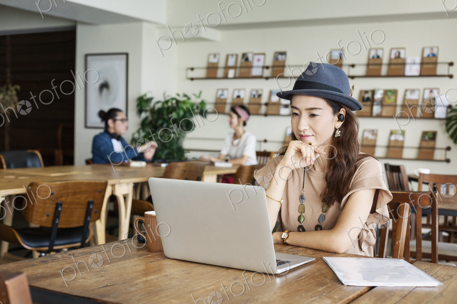 Group of young Japanese professionals working on laptop computers in a co-working space.
