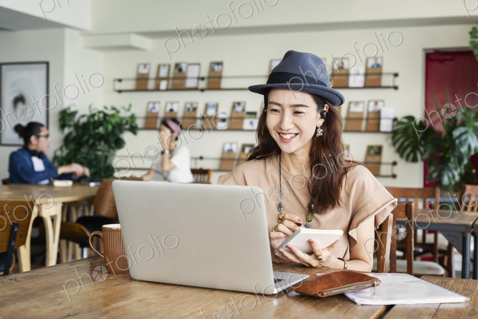 Group of young Japanese professionals working on laptop computers in a co-working space.