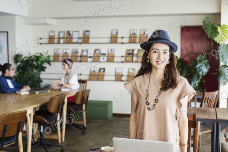 Group of young Japanese professionals working on laptop computers in a co-working space.