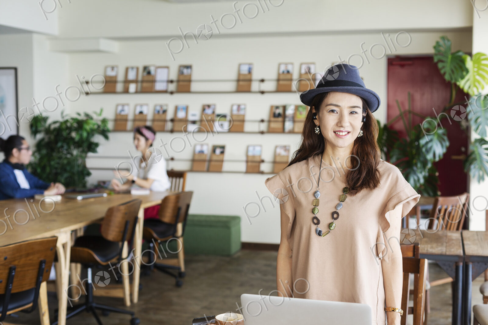 Group of young Japanese professionals working on laptop computers in a co-working space.