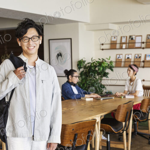 Group of young Japanese professionals working on laptop computers in a co-working space. Group of young Japanese professionals working on laptop computers in a co-working space.