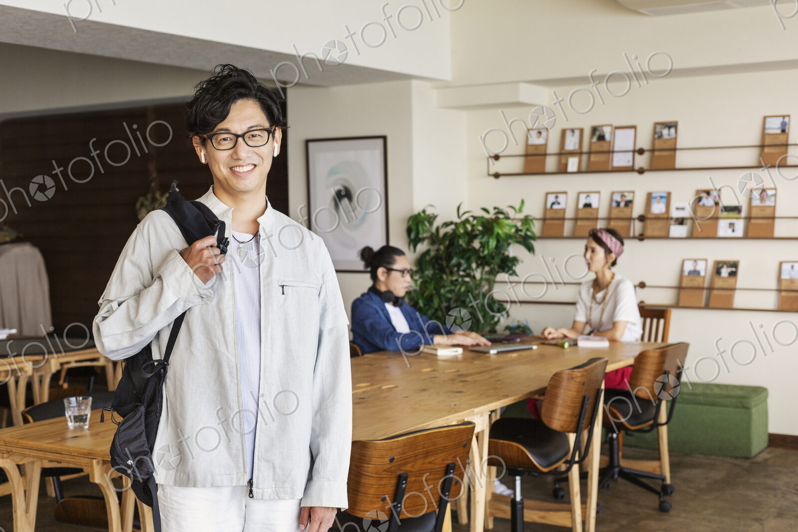 Group of young Japanese professionals working on laptop computers in a co-working space.