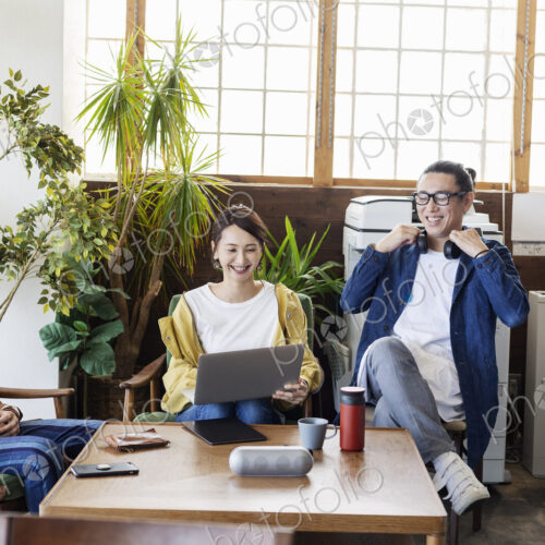 Group of young Japanese professionals working on laptop computers in a co-working space. Group of young Japanese professionals working on laptop computers in a co-working space.
