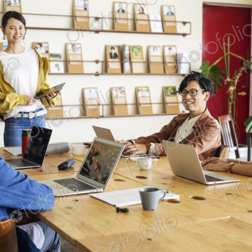 Group of young Japanese professionals working on laptop computers in a co-working space. Group of young Japanese professionals working on laptop computers in a co-working space.