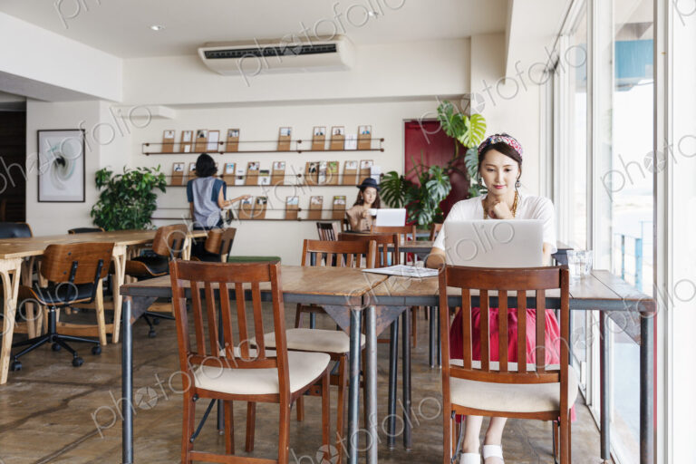 Group of young Japanese professionals working on laptop computers in a co-working space.