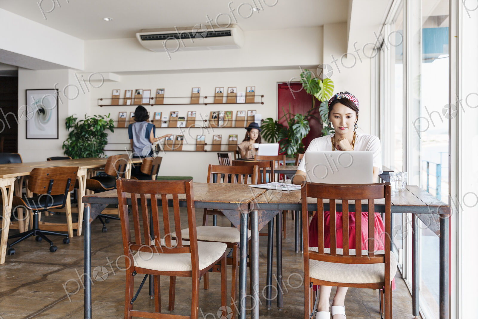 Group of young Japanese professionals working on laptop computers in a co-working space.