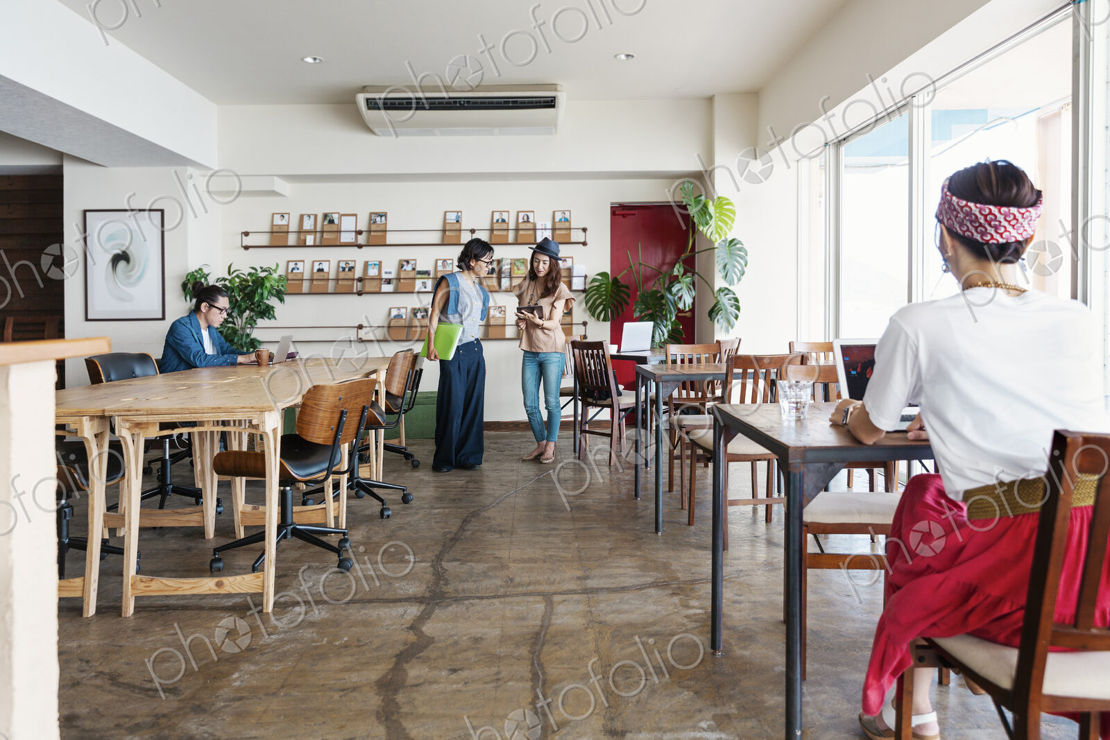 Group of young Japanese professionals working on laptop computers in a co-working space.