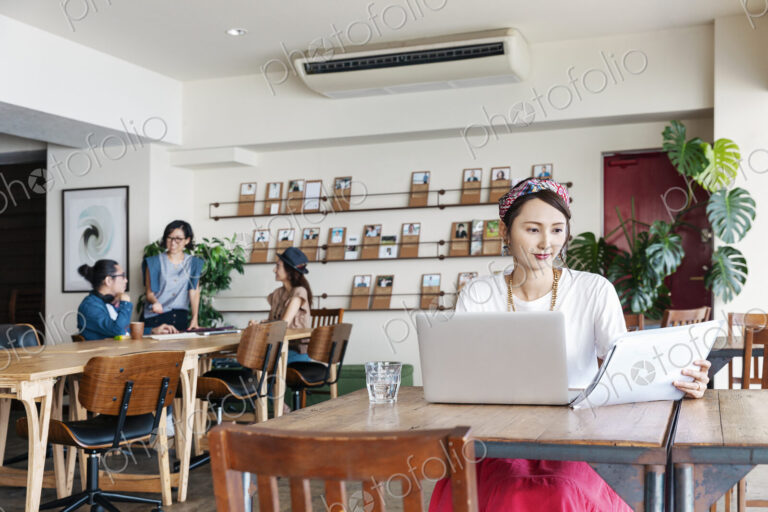 Group of young Japanese professionals working on laptop computers in a co-working space.