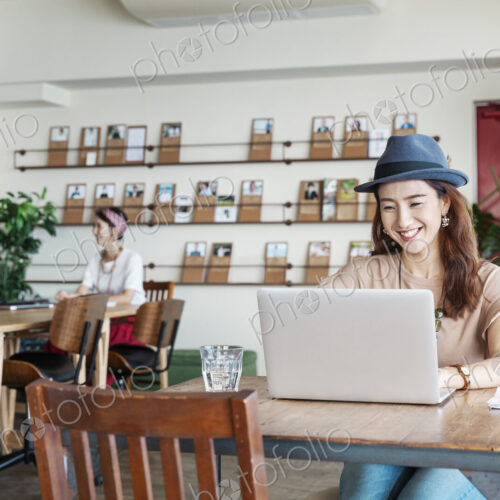 Group of young Japanese professionals working on laptop computers in a co-working space. Group of young Japanese professionals working on laptop computers in a co-working space.