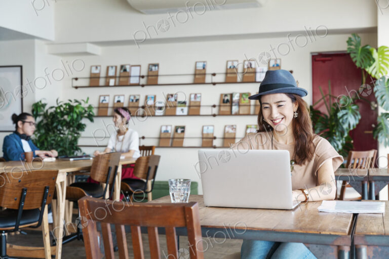 Group of young Japanese professionals working on laptop computers in a co-working space.