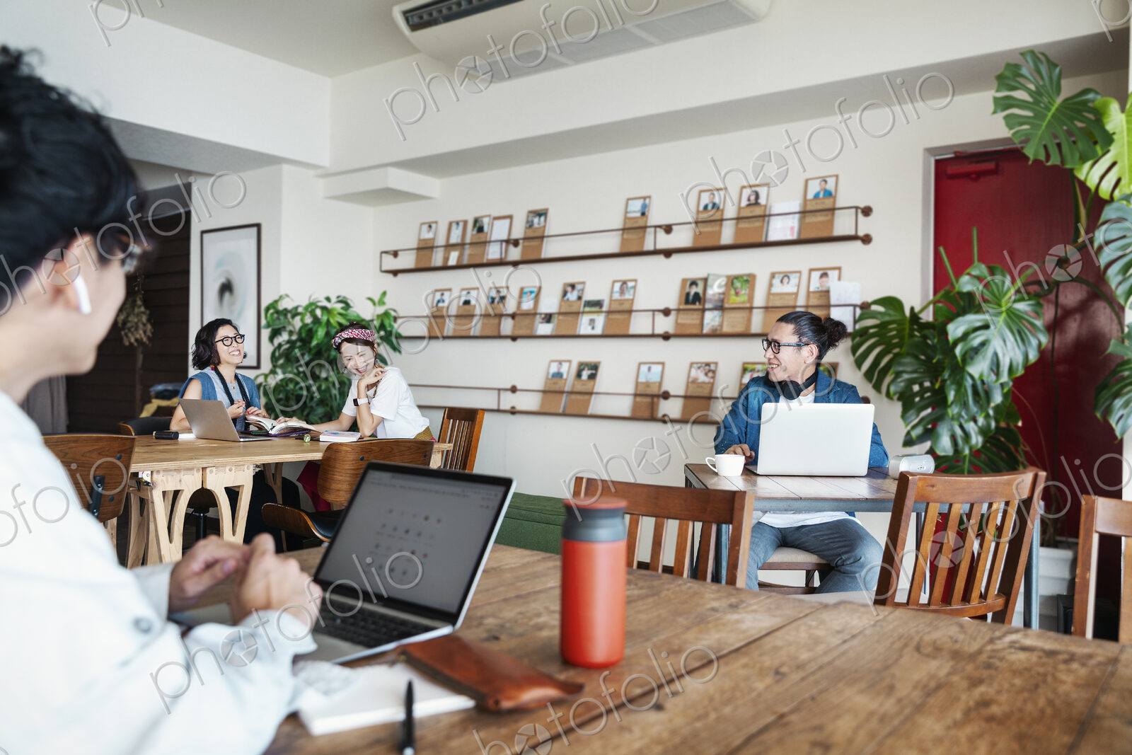 Group of young Japanese professionals working on laptop computers in a co-working space.