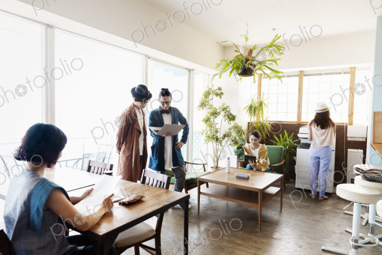 Group of young Japanese professionals working on laptop computers in a co-working space.