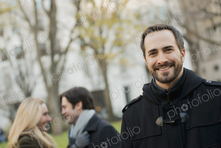 Group walking in urban park, man in front
