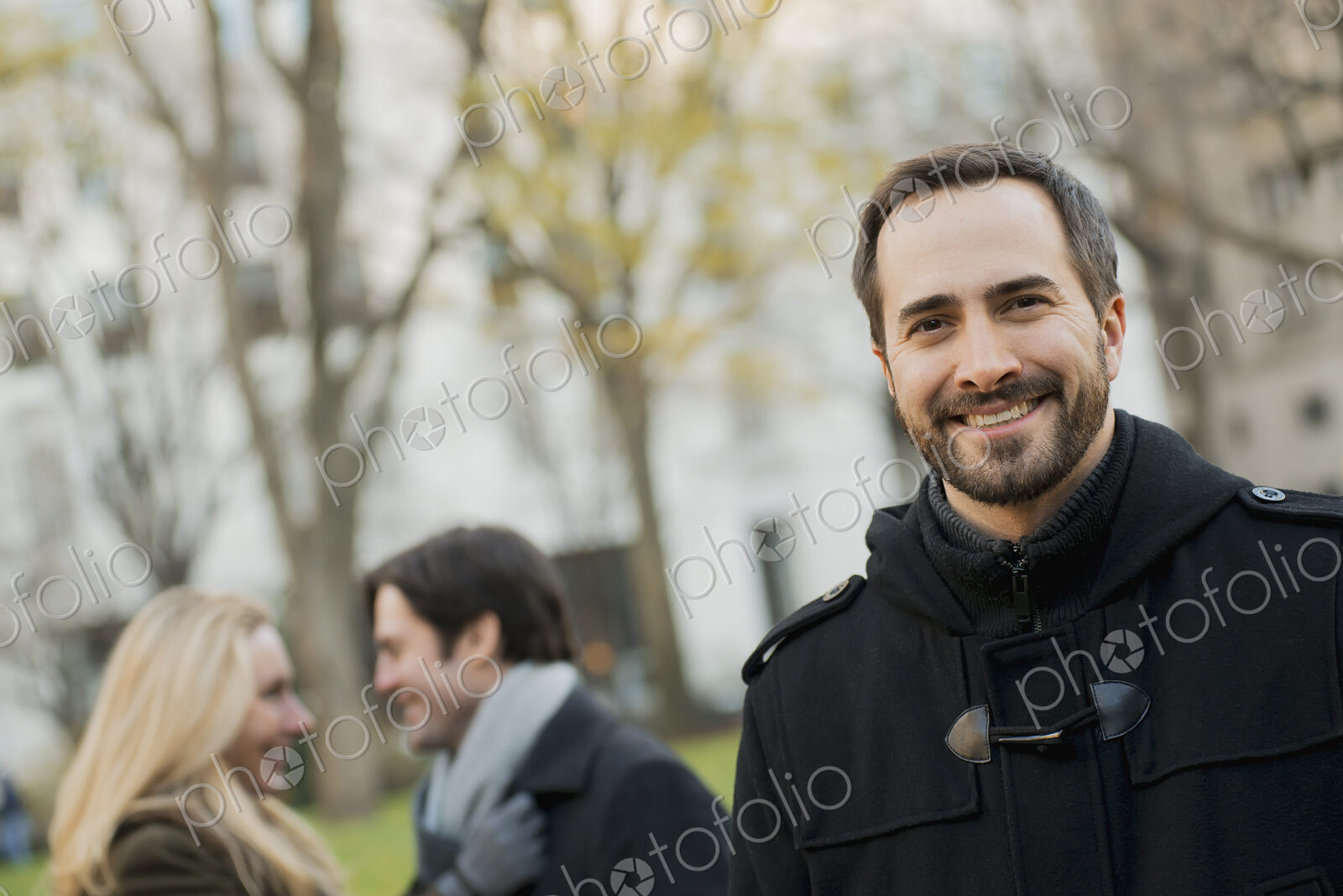 Group walking in urban park, man in front