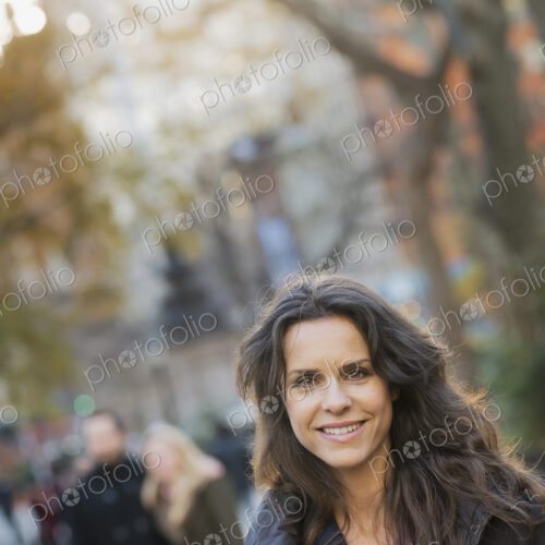 Group walking in urban park, woman in front Group walking in urban park, woman in front