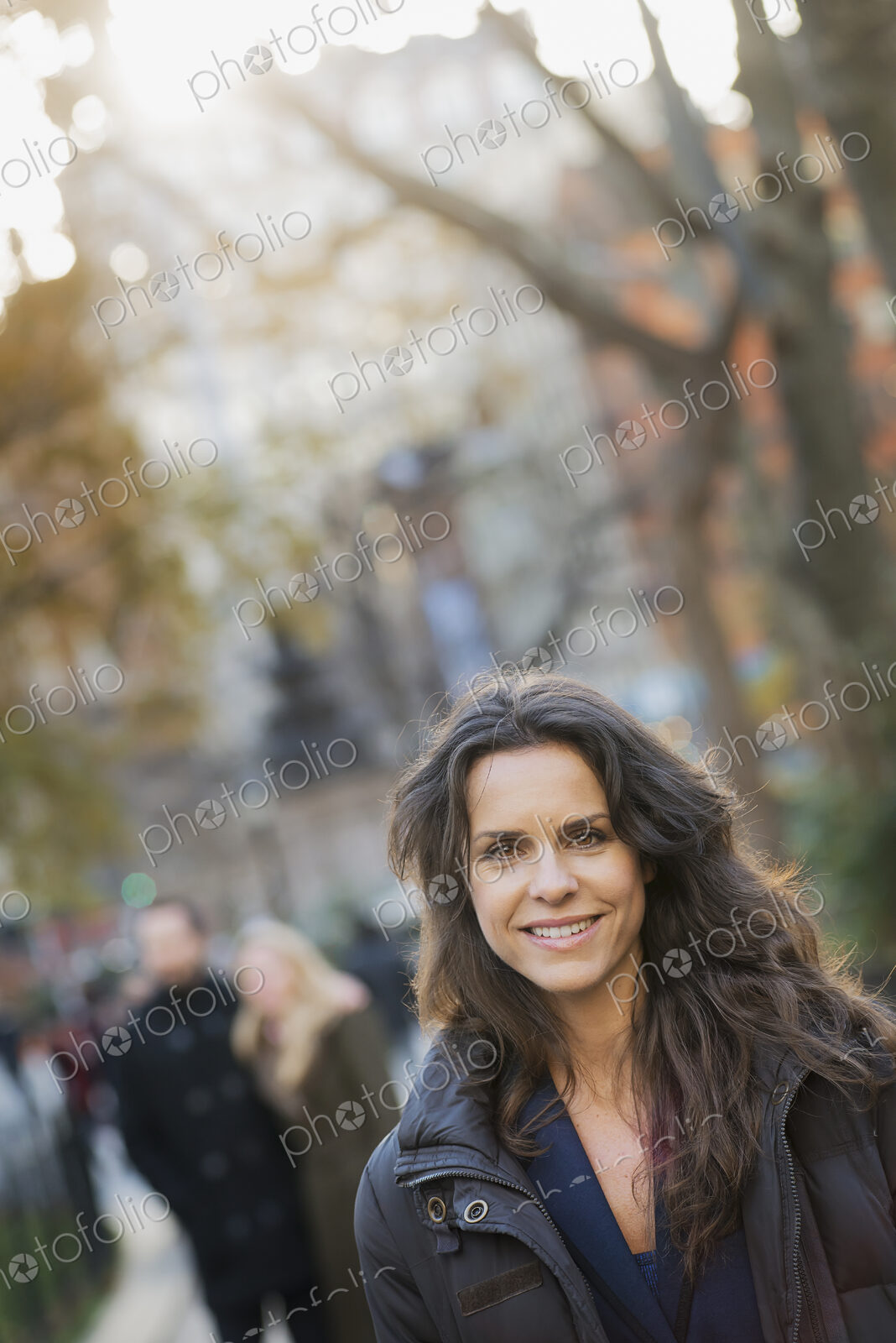 Group walking in urban park, woman in front