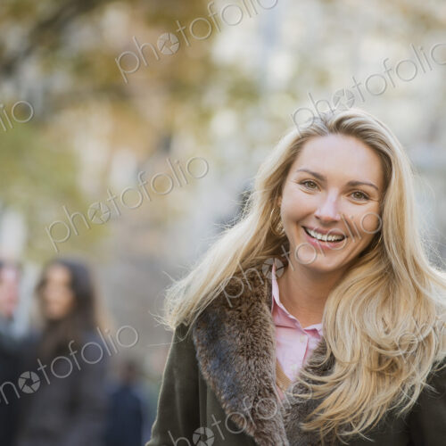 Group walking in urban park, woman in front Group walking in urban park, woman in front