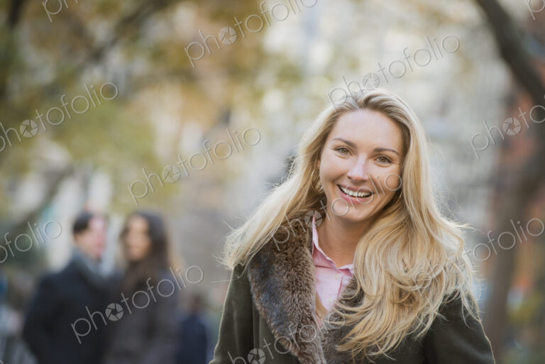 Group walking in urban park, woman in front