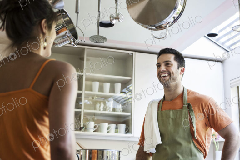 HIspanic couple at home in their kitchen.