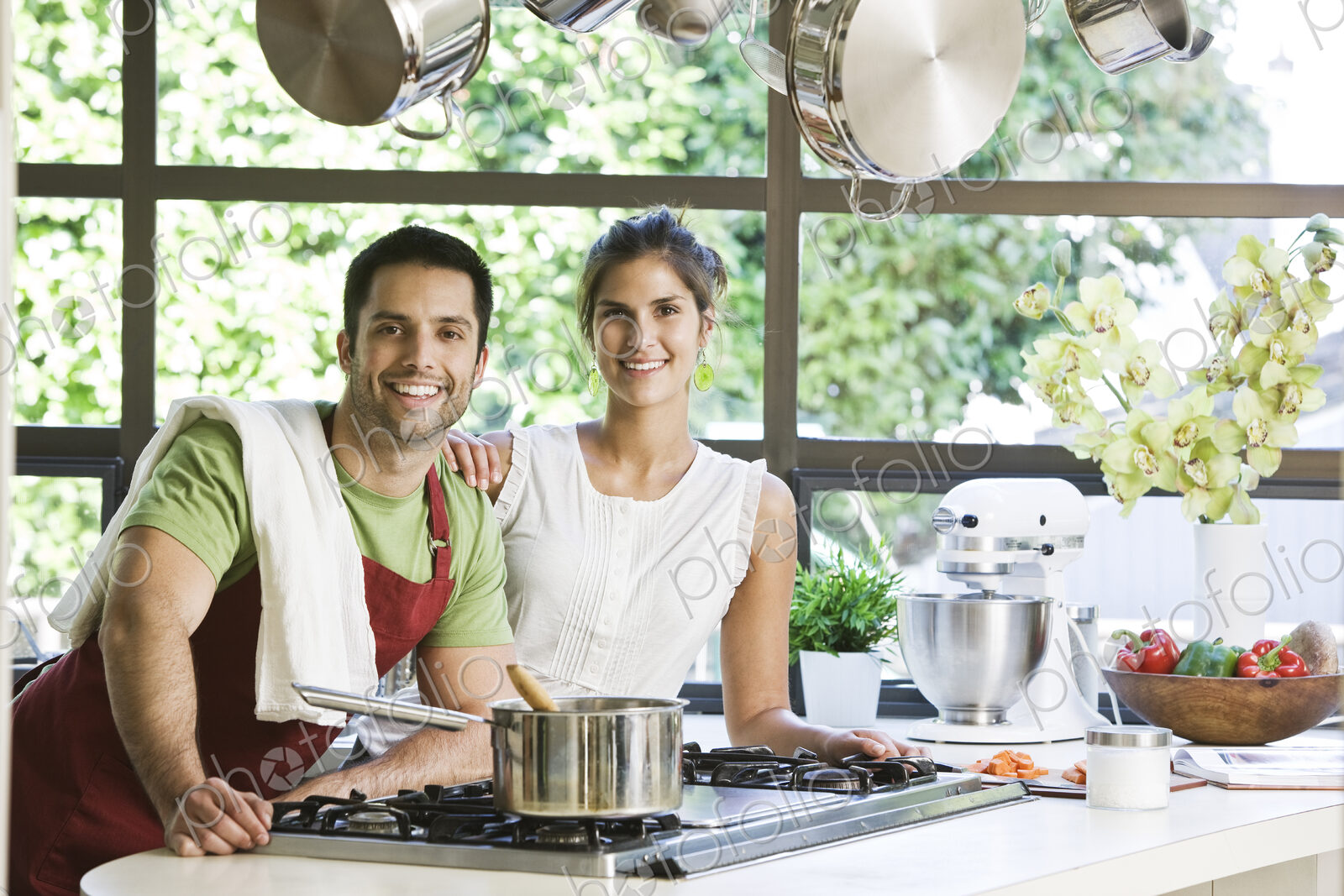 HIspanic couple at home in their kitchen cooking together.