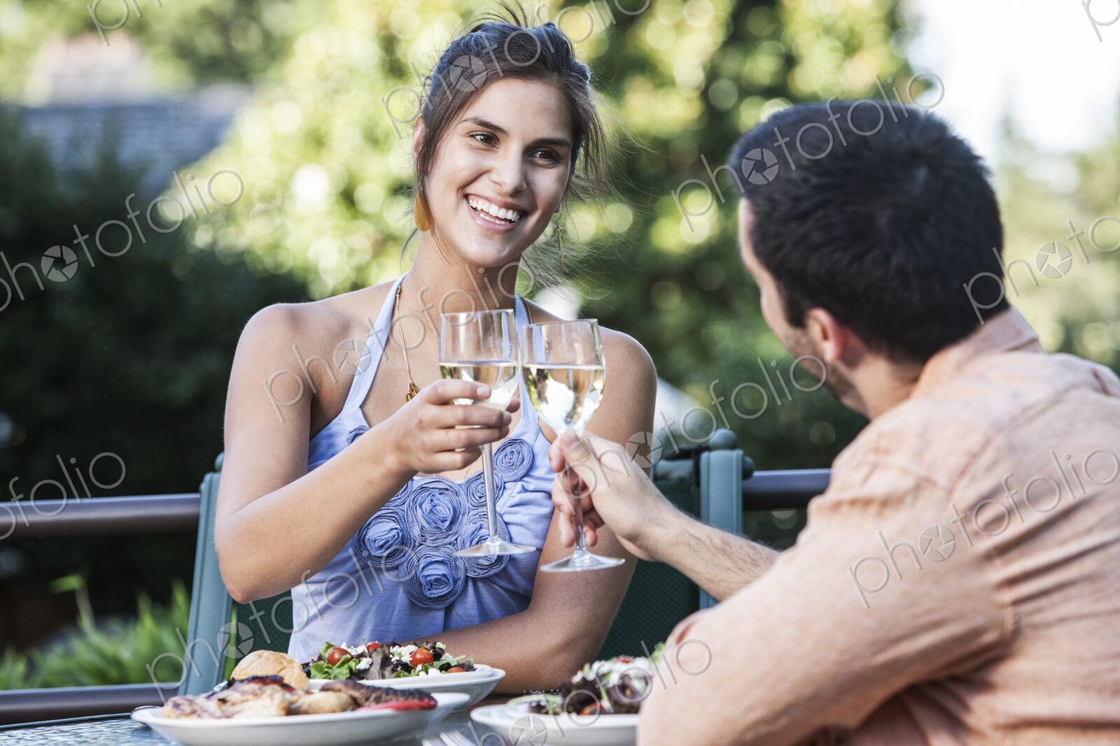 HIspanic couple having a healthy meal and a glass of white wine.