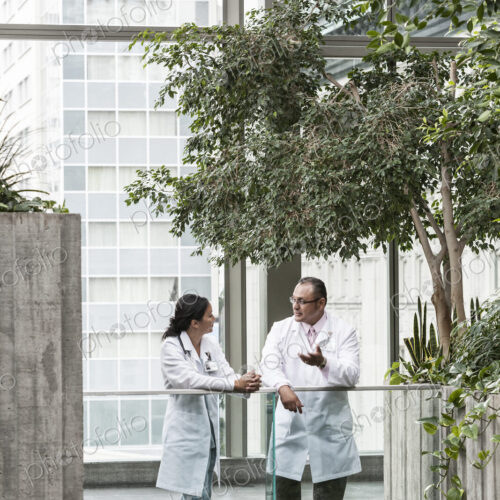 HIspanic man and asian woman doctors conferring over a case in a hospital. HIspanic man and asian woman doctors conferring over a case in a hospital.