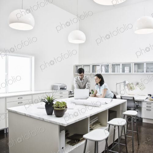 HIspanic man and woman working together in an architect's office.