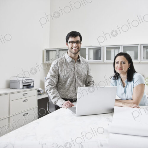 HIspanic man and woman working together in an architect's office. HIspanic man and woman working together in an architect's office.